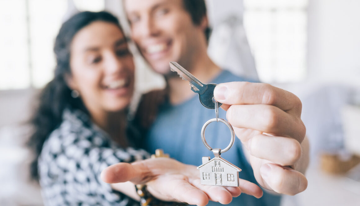 Couple cheerful home owners holding a key