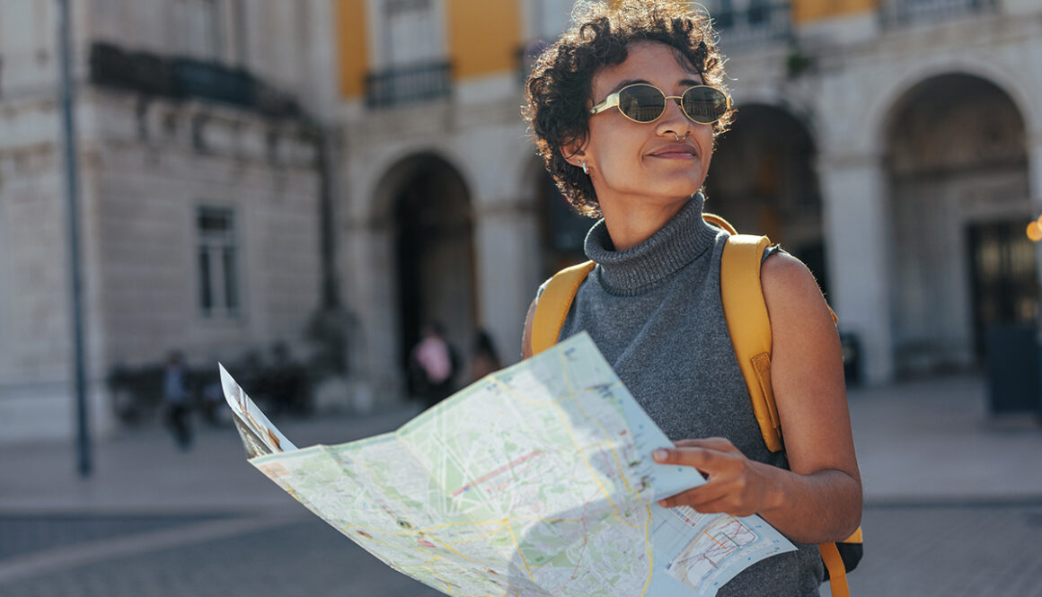 Tourist exploring lisbon with map and backpack enjoying summer vacations